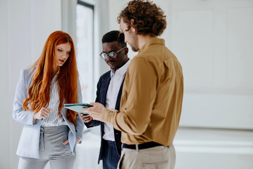 Group of three young business people searching commercial real estate for their company.